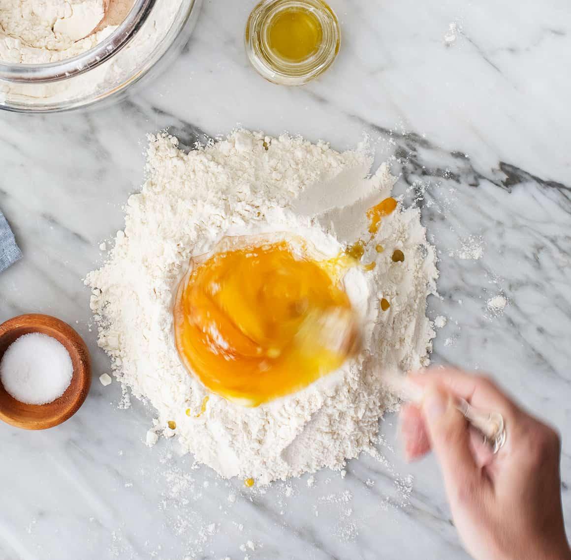 Whisking eggs in mound of flour