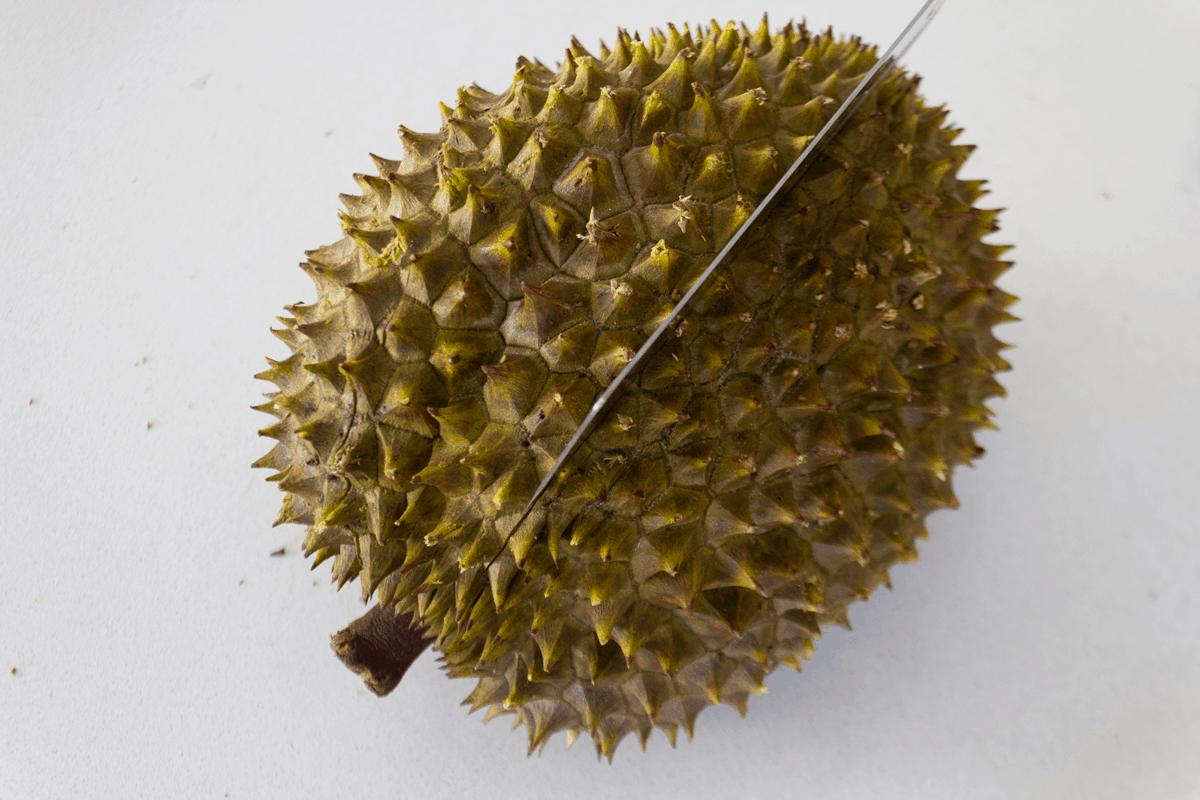 A cleaver cutting into a durian.